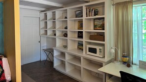 A room with a white shelving unit, a small table with a microwave, and a window with curtains. - Private Writers Room at SaddleRock Ranch in Heart of Sedona (Sedona)