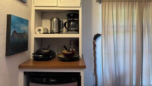 A kitchen with a coffee maker, kettle, and a painting on the wall. - Private Writers Room at SaddleRock Ranch in Heart of Sedona (Sedona)