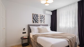 A modern hotel room with a bed, bedside table, wall art, and an air conditioning unit. - Villa Verde Ra anj With Heated Pool (Rogoznica)