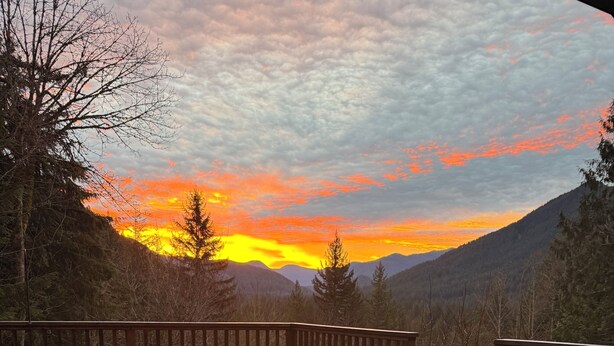 A wooden deck with Adirondack chairs, overlooking a mountainous landscape during sunset. - Secluded 5BR Cabin, Hot Tub, Views, Mt Hood (Rhododendron)