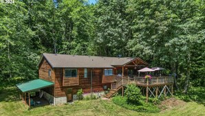 A wooden cabin with a deck, a covered patio, and a natural forest backdrop. - Secluded 5BR Cabin, Hot Tub, Views, Mt Hood (Rhododendron)