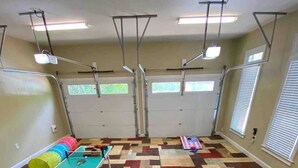 Une pièce équipée d’une table de ping-pong, de matériel d’exercice et d’un tapis à motifs.