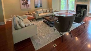 Un salon spacieux comprenant un ensemble de canapés, une table basse et une cheminée.
