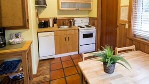 Una cocina compacta con estufa, lavamanos y armarios de madera.