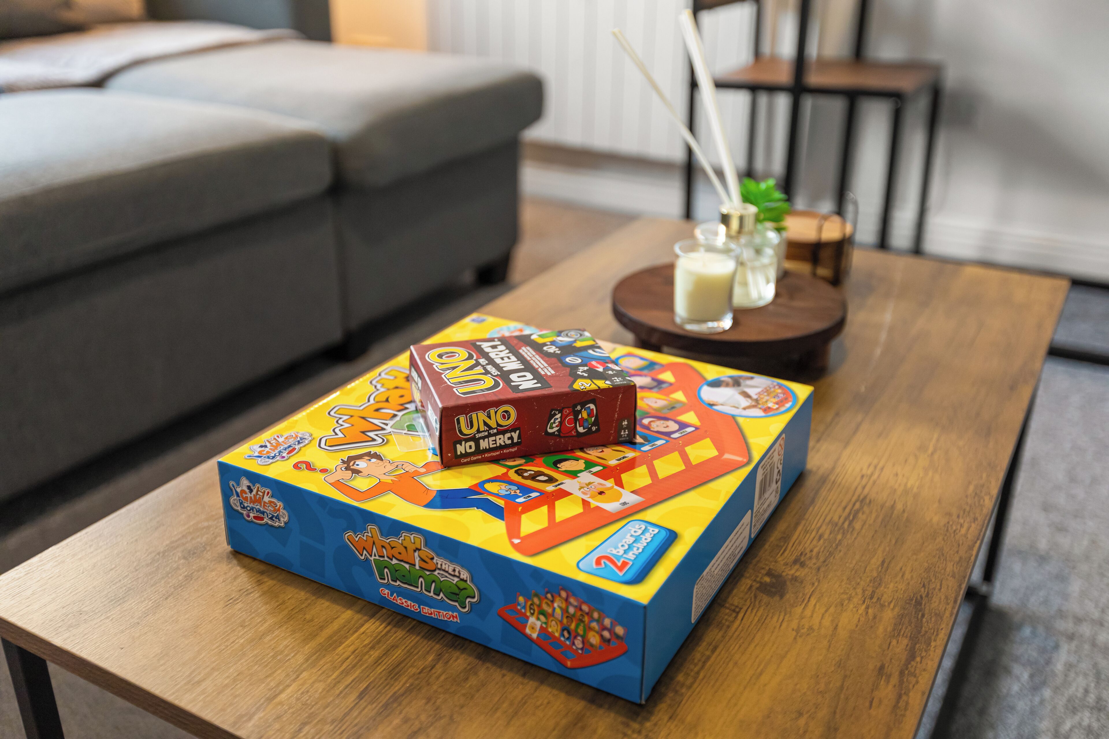 A board game titled 'UNO' on a wooden table in a living room.