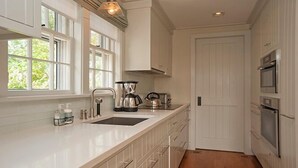 A kitchen with white cabinetry, a sink, a coffee maker, and an oven. - 2.5 bedroom, 2.5 bathroom (Nantucket)