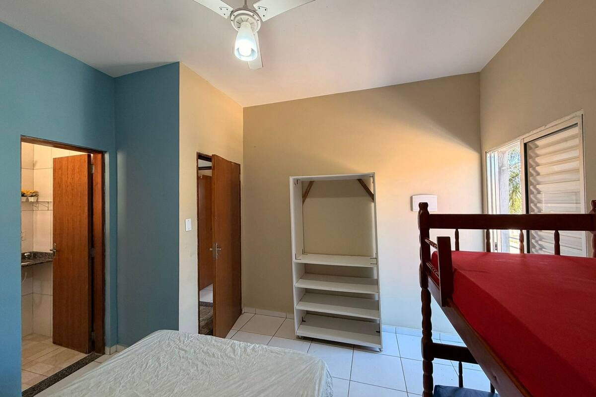 A room with a bed, a wardrobe, a closet, and a window with blinds.