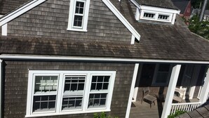 A residential house with a gabled roof, a front porch with a bench, and a chimney. - 1 Bedroom with loft, 1 bathroom (Nantucket)