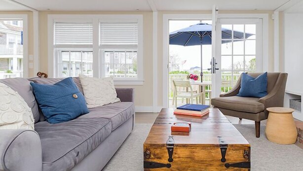 A living room with a grey sofa, a wooden coffee table, and a brown armchair. - 2 bedroom, 2 bathroom (Nantucket)