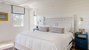 A bedroom with a bed, nightstands, a lamp, and a picture frame on the wall. - 2 bedroom, 2.5 bathroom (Nantucket)