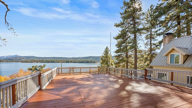 A wooden deck with a railing, overlooking a lake and forested hills. - Eads by the Lake (Fawnskin)
