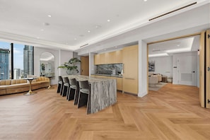 Ein modernes Interieur mit Kücheninsel, Essbereich und Sofa.