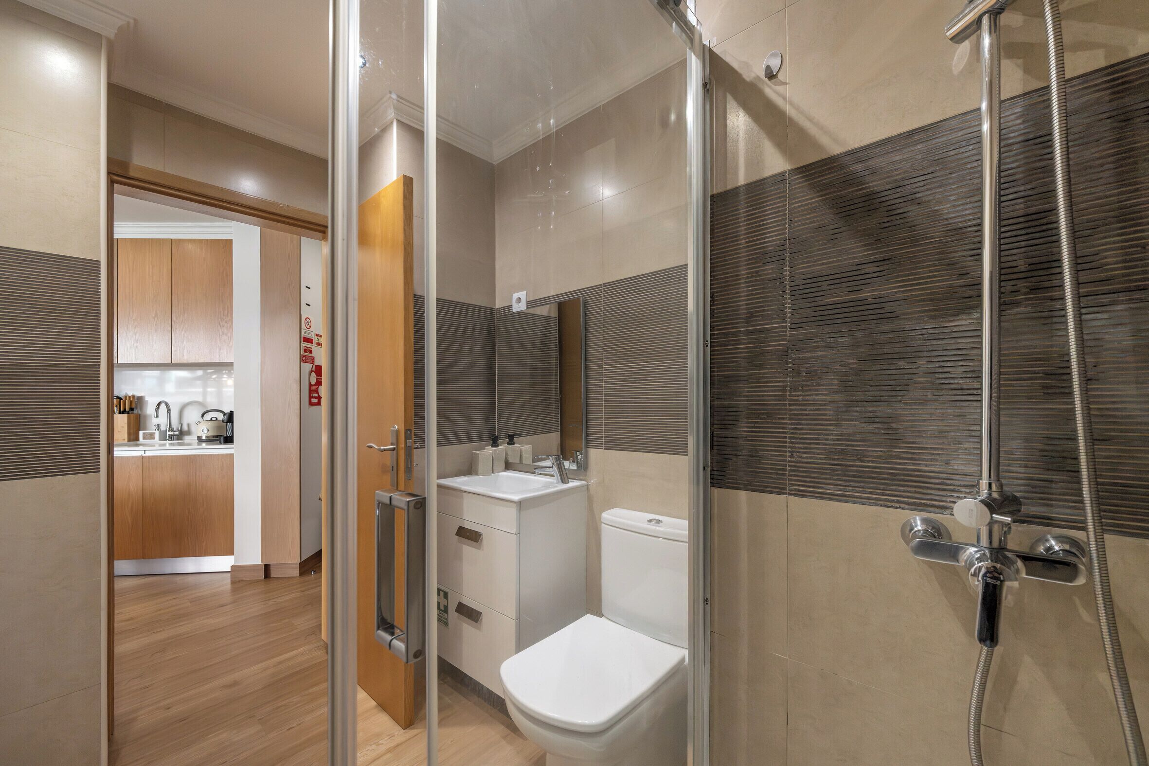 A modern bathroom with a shower, toilet, and sink.