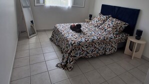 Une chambre à coucher avec un lit, une table de chevet, un miroir et une fenêtre.