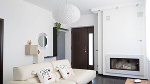 Ein modernes Wohnzimmer mit einer Couch, einem Kamin und einer Pendelleuchte.