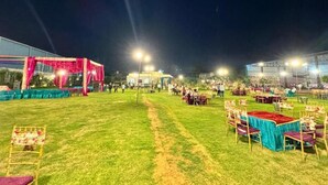 An outdoor event space with tables and chairs, a stage, and lighting. - 2BR Villa with Pool, BBQ & Music at GoBravo Grandeur Gurgaon (Gurugram)