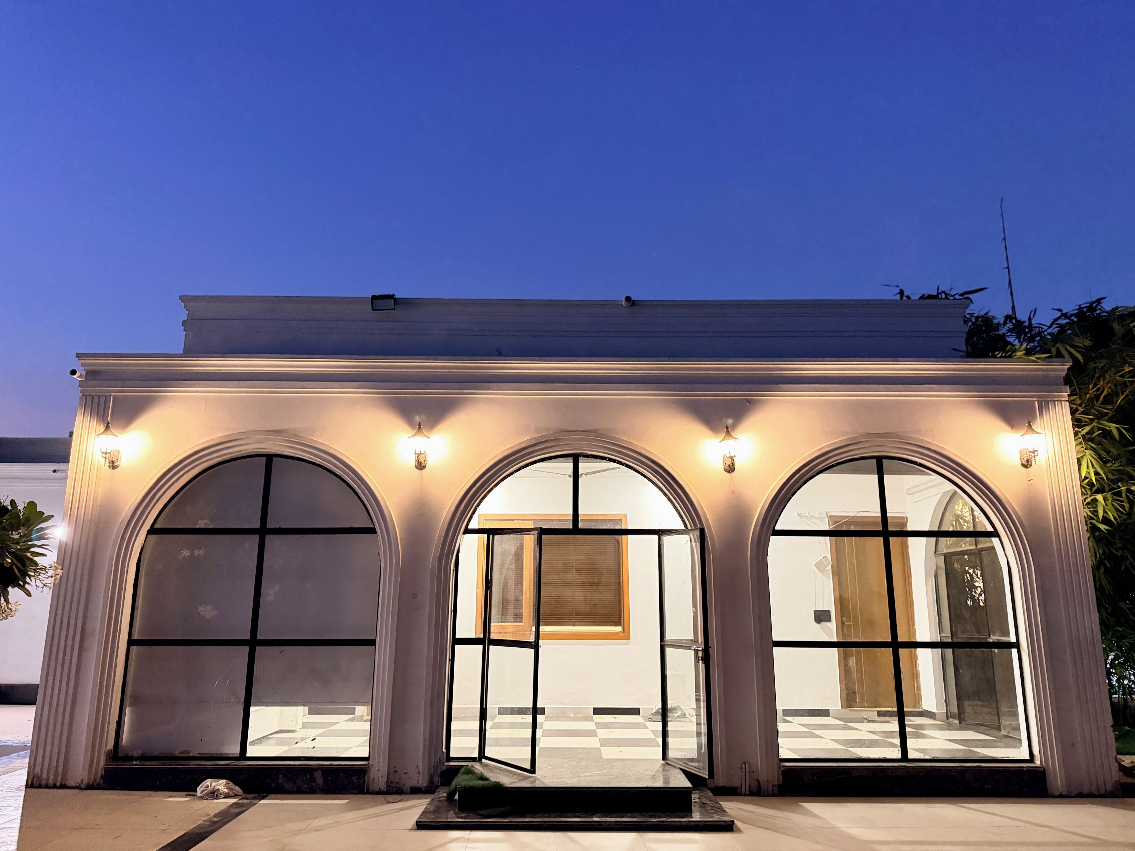 Un bâtiment doté de trois fenêtres en arc et d’un toit plat.