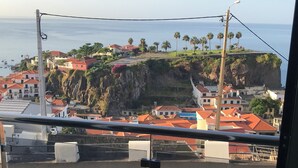 Eine Küstenstadt mit Häusern, einer Klippe und Blick auf das Meer.