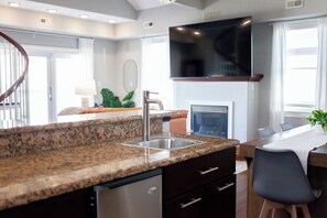 A modern kitchen with granite countertops, a stainless steel sink, and a built-in dishwasher. - Serenity on the Shore (Virginia Beach)