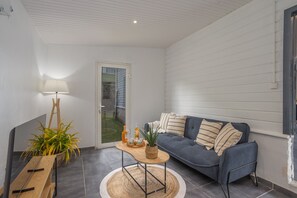 A modern living room with a sofa, a coffee table, a lamp, and a potted plant. - La Villa Timalo - Piscine Privée (Case-Pilote)