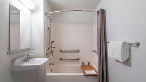 A bathroom with a sink, mirror, shower, and towel rack. - Vagabond Inn - Santa Barbara (Santa Barbara)