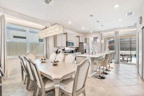 Una cocina moderna con comedor, ventanas amplias y vistas al exterior.