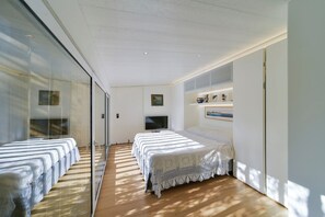 A modern bedroom with a large bed, a TV, and a glass wall. - The Stone Pine House - Paraggi (Santa Margherita Ligure)