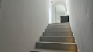 Eine modern gestaltete Treppe führt zu einer Empfangsebene mit einer Tür.