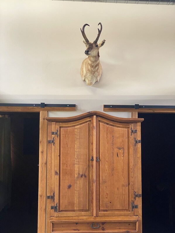 Un meuble en bois doté de charnières métalliques et orné d’une tête d’animal fixée sur le devant.