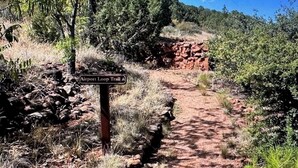 En støvet sti med et skilt, der viser 'Airport Loop Trail'.