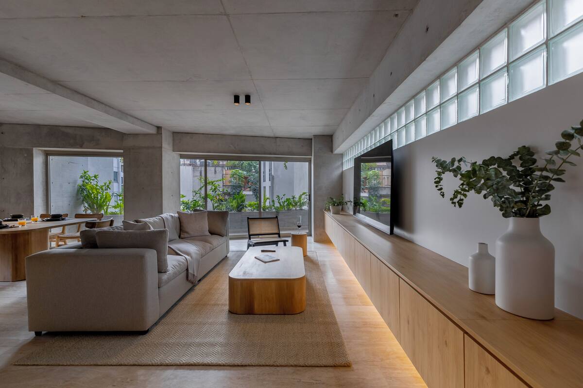 Uma sala de estar moderna com sofá, mesa de centro e plantas em vasos.