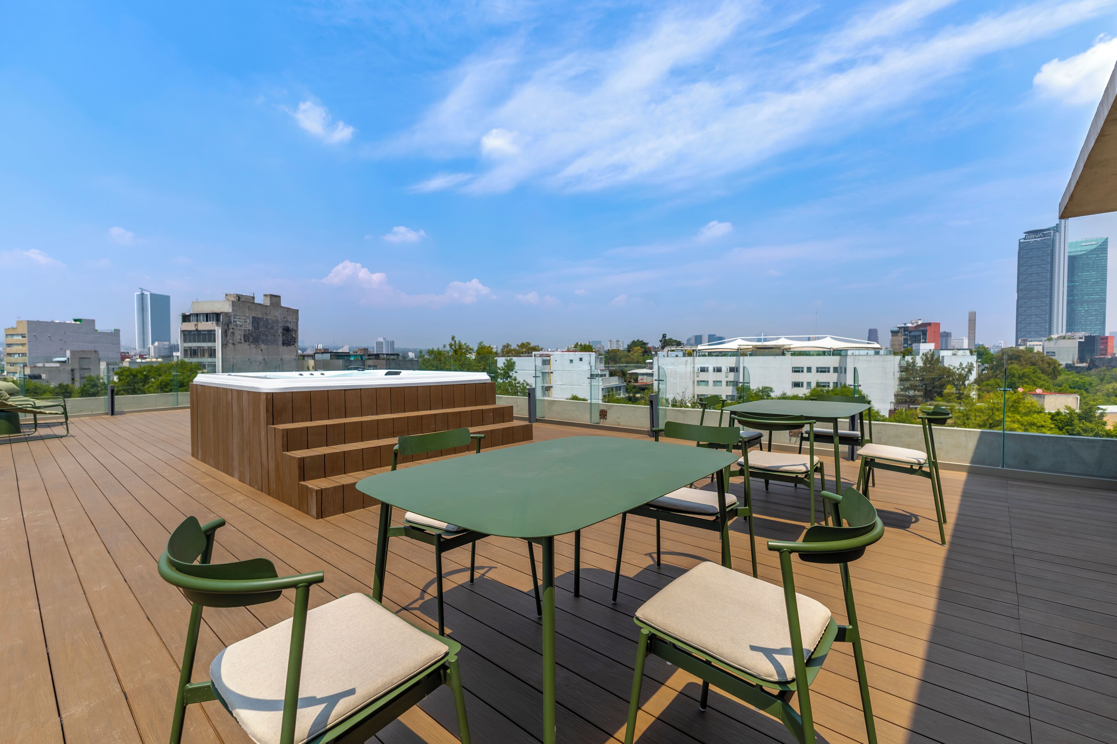 A rooftop deck with outdoor seating, a hot tub, and a city skyline view.