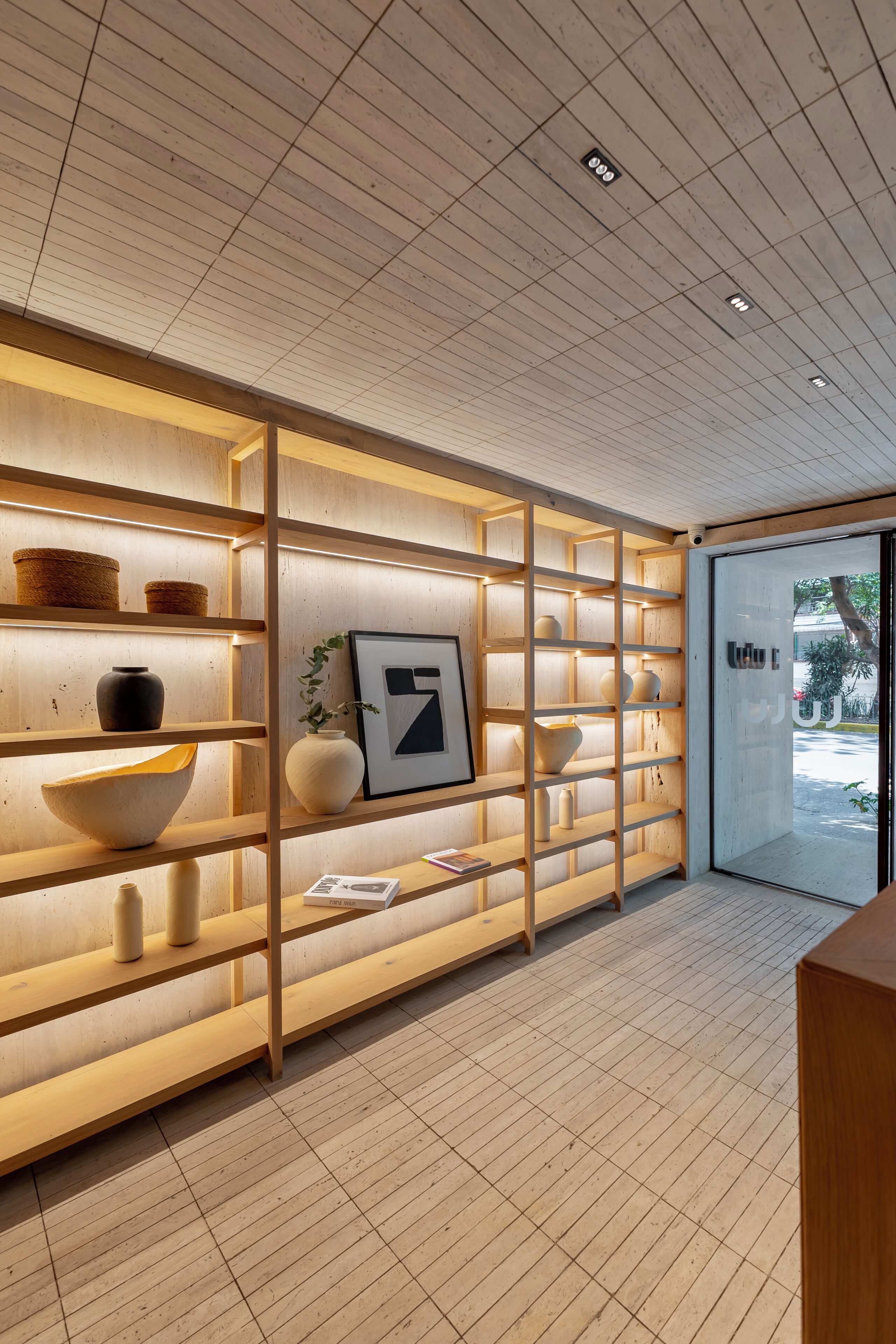 Ein modernes Interieur mit Holzbögen, die dekorative Gegenstände und ein gerahmtes Kunstwerk zeigen.
