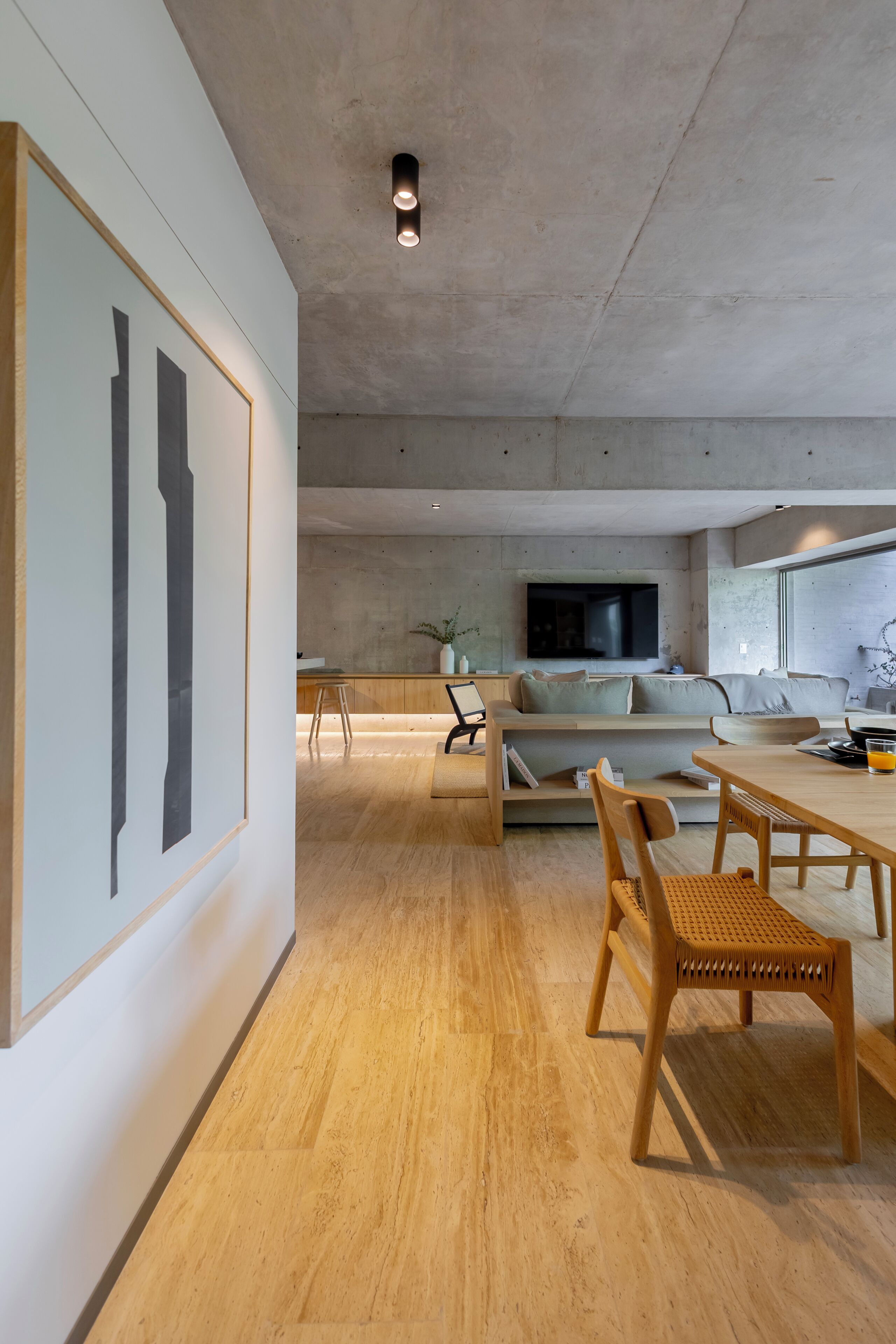 Un salon moderne comprenant un canapé, un téléviseur et un coin repas avec des chaises et une table.