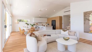Un salon moderne avec un canapé d’angle, une table basse et un coin repas comprenant des chaises et une table.