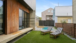 A modern house with a pool, two lounge chairs, and a well-maintained lawn. - Modern House, walk to French Quarter or the street car is a block away! (New Orleans)
