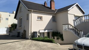 Ein zweistöckiges Haus mit Balkon, Schornstein und Garage.