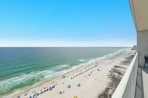 A beach view from a balcony with a clear sky, a sandy beach, and ocean waves. - Seawind 1804 | Beachfront | Pool | Hot Tub | My Beach Getaways (Gulf Shores)