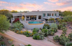 A modern house with a swimming pool, surrounded by landscaped gardens and desert plants. - On The Green | Troon Golf Estate | Guest House, Negative Edge Pool, Spa, Patios, Gated (Scottsdale)