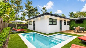 A modern house with a swimming pool, a patio with outdoor furniture, and a well-maintained garden. - Modern Home • Pool • Near Beach & Las Olas (Fort Lauderdale)