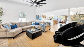 A spacious living room with a large sofa, a coffee table, and a ceiling fan. - 2 Homes! - 4 MN to Madiera BCH - Hottub - HTD Pool (St. Petersburg)