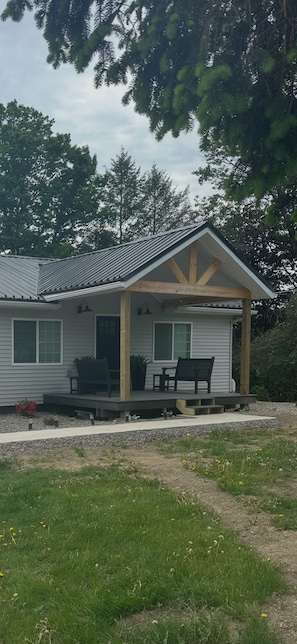 Uma casa térrea com varanda, um pequeno deck e uma porta de entrada.