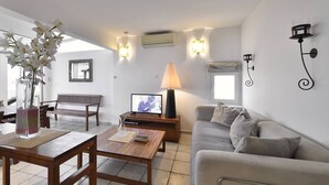 A living room with a sofa, a coffee table, a TV, and a lamp. - PAPRIKA - Villa Port Nature 69 - Luxury - 4 people (AGDE)