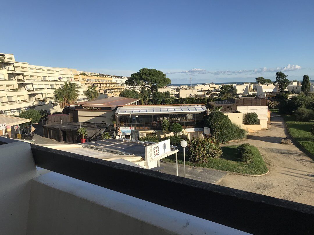 Blick auf die Küste mit einem Gebäude, auf dem 'Walki beach' steht, und einem wolkenlosen Himmel.