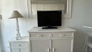 A white cabinet with a television, a lamp, and a chair. - Port Nature Studio 627 - 3 people (AGDE)