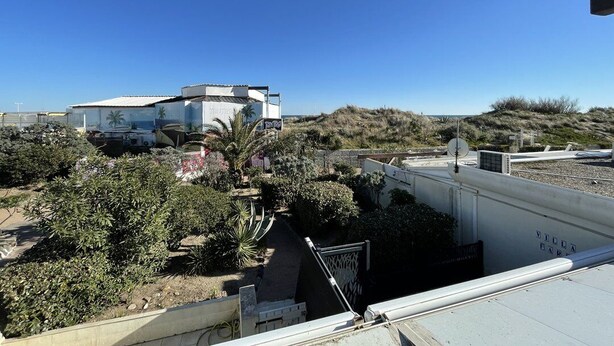 A building with a flat roof, surrounded by vegetation and a clear sky. - DUNE - Villa Port Nature 66 - Luxury - 4 people (AGDE)