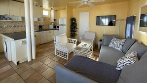A compact living space with a kitchenette, a ceiling fan, a flat-screen TV, and a sofa. - DUNE - Villa Port Nature 66 - Luxury - 4 people (AGDE)
