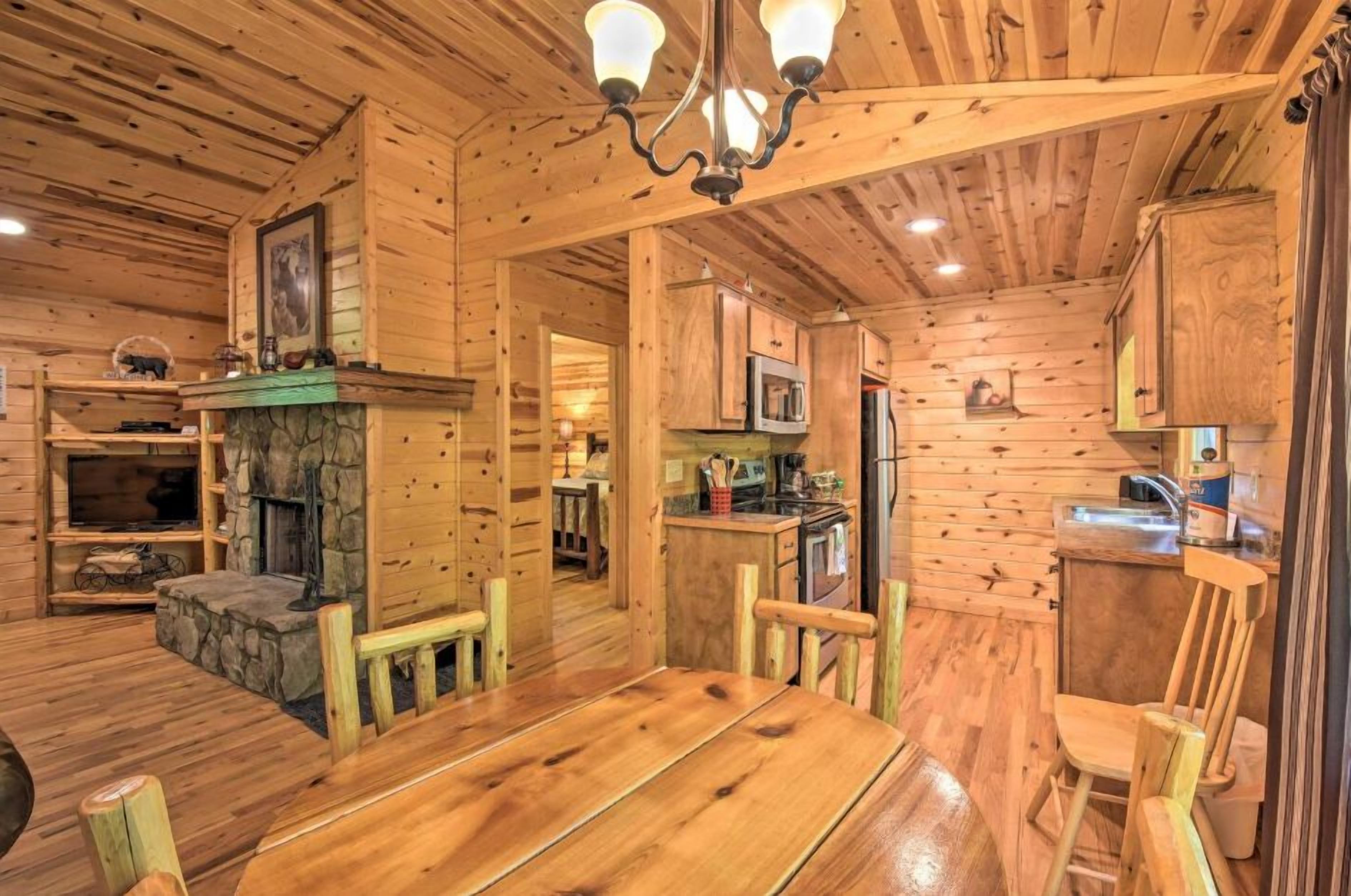 Ein Holzblockhaus-Innenraum mit Essbereich, Küche und Kamin.