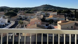 Zona residencial con casas, cielo despejado y una colina en la distancia.