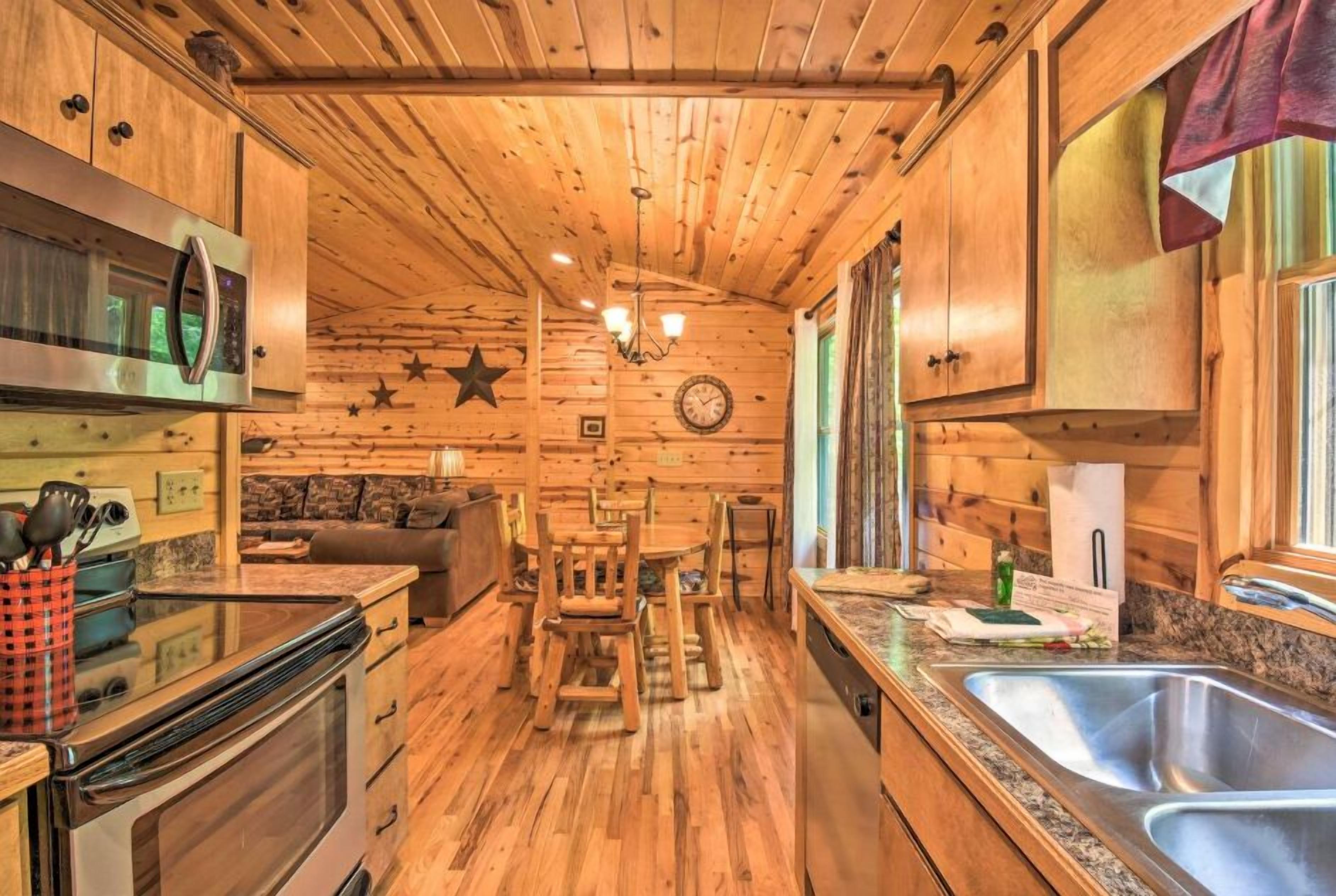 Een houten cabin met een keuken, een eethoek en een gezellige zithoek.